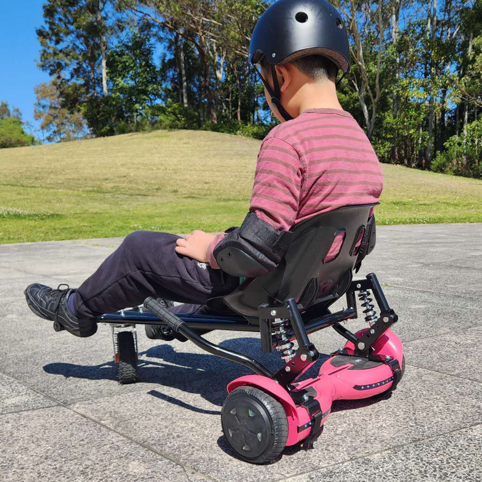 A child enjoys a sunny day out riding the RIDEO Hoverboard Go-Kart in a striking pink color, showcasing the fun and safety of the model.