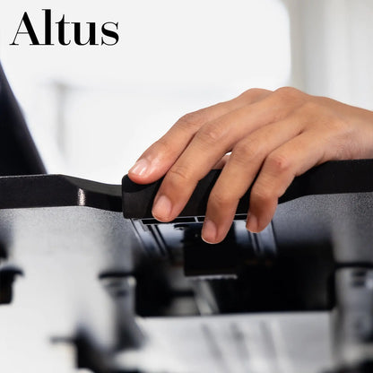 Close-up of a woman's hand adjusting the lever of a black desk riser.