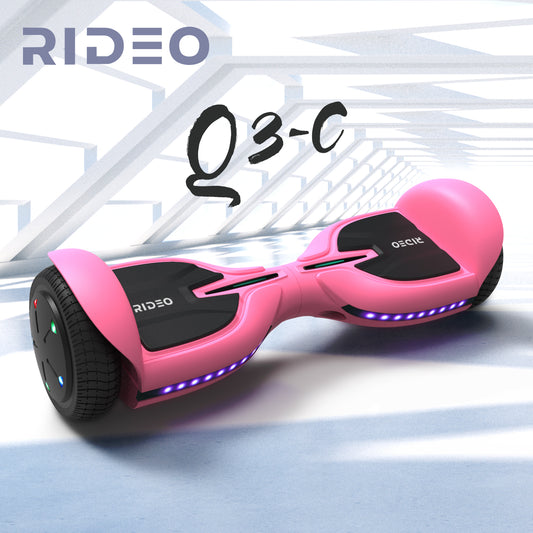 Dynamic portrayal of a pink RIDEO Q3-C hoverboard in a modern, architectural environment, highlighting its sleek design and vibrant undercarriage lighting.